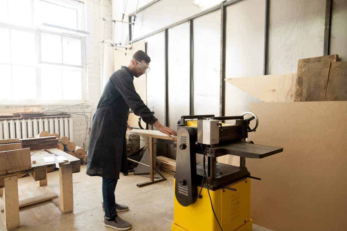 man working on wood thickness planer